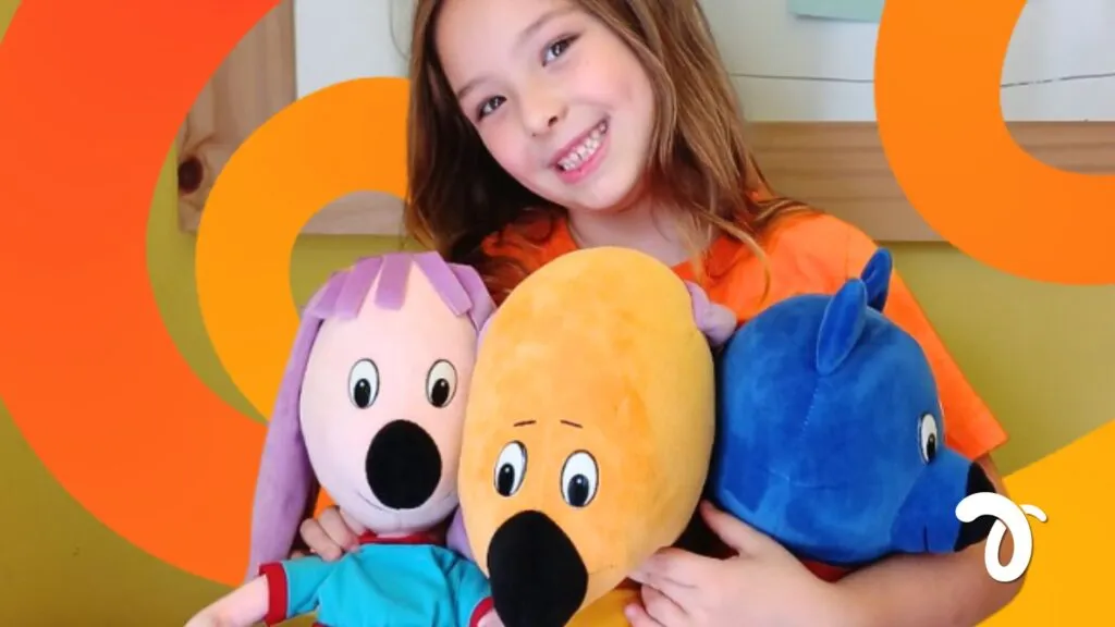 Aluna sorrindo com os personagens do programa LIV de educação socioemocional na Trails School